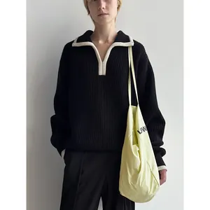 Loose knit sweater in black with contrasting white polo collar and relaxed silhouette