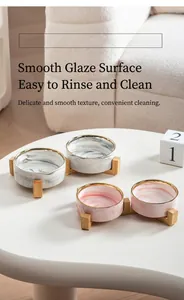 Detail of marble pattern ceramic pet bowls with gold rim on a minimalist wooden stand