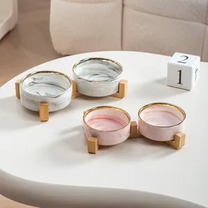 Double gamelle en céramique marbrée avec bord doré et support en bois ergonomique