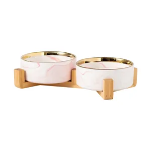 Double gamelle en céramique marbre rose avec bord doré et support en bois