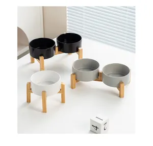 Detail van verhoogde bamboe standaard met keramische voerbakken in zwart wit en grijs