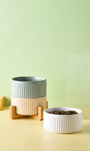 Detail of three ceramic pet bowls in pastel colors with a detachable cross wooden stand