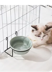 Detail of a hanging ceramic cat bowl with marble texture and black metal cage mount