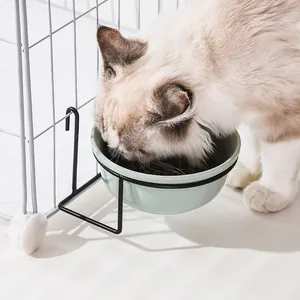 Hanging ceramic pet bowl with black metal frame fixed on a cage for cats and dogs
