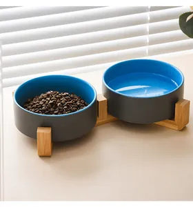 Detail of ceramic pet double bowl set with bamboo stand showing dry food and water