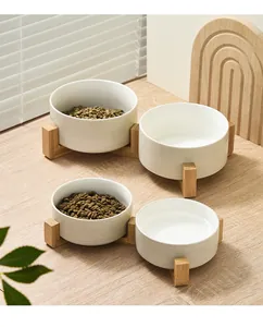 Detail of ceramic pet bowls with wooden stand showing white texture and cat food