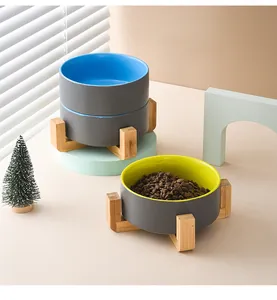 Detail of elevated ceramic pet bowl with bamboo stand showing kibble inside a blue basin