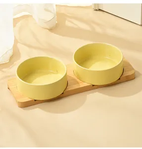 Dual yellow ceramic cat bowls set with a natural bamboo stand in a minimalist room