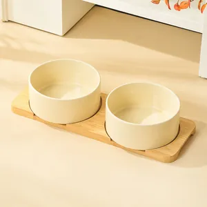 Minimalist double ceramic cat bowls with bamboo stand in a warm home setting