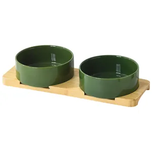Ceramic cat bowl set with two dark green ceramic bowls on a natural bamboo stand