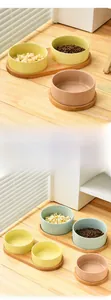 Detail of macaron ceramic cat bowls with natural bamboo stand on a wooden table