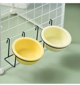 Detailansicht der hängenden Keramik-Näpfe in Gelb und Creme mit schwarzen Metallhaken