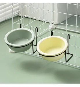 Details von hängenden Keramik-Futternäpfen in Grün und Creme am weißen Gitter