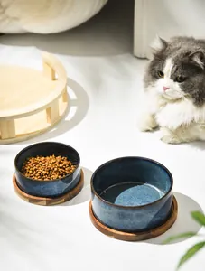 Macro detail of the dark blue ceramic cat bowls with natural wooden base texture