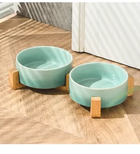 Dettaglio di ciotole doppie in ceramica con supporto in bambù al sole