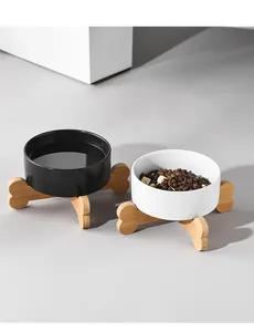 Modern elevated ceramic pet bowls with bone-shaped wooden stands for food and water
