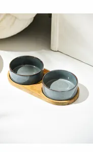 Detail of detachable double ceramic pet bowls on a bamboo stand for water and food
