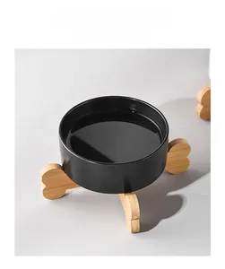 Detail of matte black ceramic cat bowl with raised bone-shaped bamboo stand for neck protection