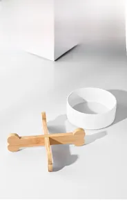 Detail of detachable white ceramic cat bowl with a bone-shaped wooden stand for neck protection