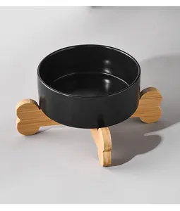 Close-up of black ceramic cat bowl with stylish cross-shaped bamboo stand for pet health