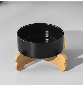 Minimalist matte black ceramic cat bowl with crossed wooden stand on grey background