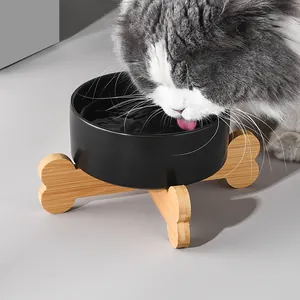 Black matte ceramic cat bowl on a bone-shaped wooden stand for neck protection