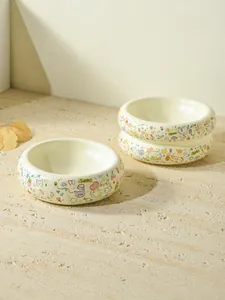 Detailed view of three ceramic cat bowls with colorful cartoon feline and heart patterns