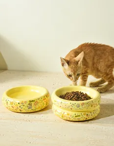 Detail of yellow ceramic cat bowls with cartoon illustrations and steady anti-tip design