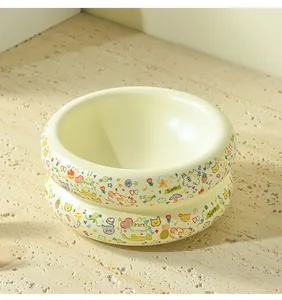 Vue détaillée de bols pour chats en céramique jaune crème avec motifs de chats et de fruits