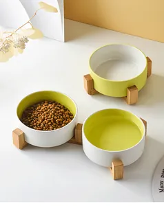 Three ceramic pet bowls with minimalist wooden stands showing food and water