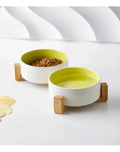 Detail of ceramic double pet bowl set with green interior and bamboo wooden stand