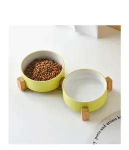 Close-up of double green ceramic pet bowls with wooden stand for food and water