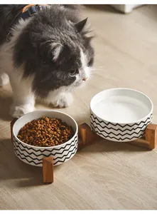 Detail of raised double ceramic pet bowls with black zigzag pattern on a wooden stand