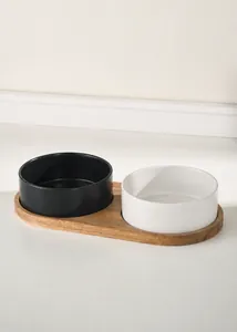 Detail of acacia wood stand with matte ceramic bowls for pet feeding and water