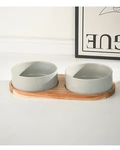 Dual ceramic pet bowls on a natural acacia wood stand in a modern minimalist style