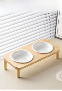 Detail of minimalist double ceramic pet bowls set in a natural light wood stand