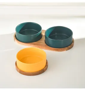 Deep green and yellow ceramic pet bowls on solid acacia wood trays for cats and dogs