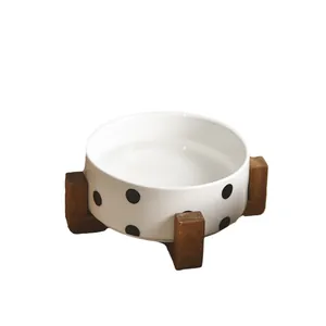 Polka dot ceramic cat bowl with triangular wooden stand in a minimalist Nordic style