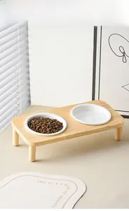 Detailed view of elevated wood pet stand with two white ceramic cat food bowls