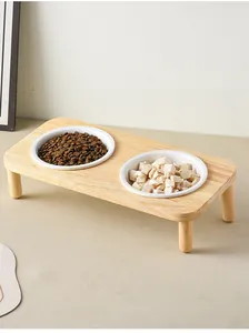 Close-up of double elevated ceramic pet bowls with natural wood stand for cats and dogs