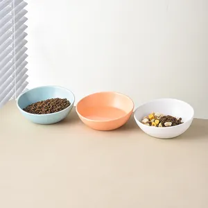 Drei farbige Keramik-Tiernäpfe für Futter und Wasser in einer minimalistischen Umgebung