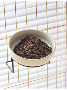 Hanging ceramic pet bowl with black metal hook stand for cage showing dry food detail