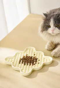Detail showing cream ceramic slow feeder bowl with textured bumps and a long-haired cat