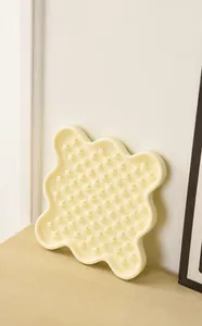 Detailed view of cream ceramic slow feeder pet bowl with textured star pattern for cats