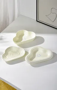 Close-up of cloud-shaped ceramic pet bowls with cute smiley face design for cats and dogs
