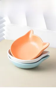 Stack of cat-ear shaped ceramic pet bowls in matte orange, white and light blue finish