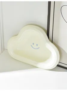 Macro detail of cream cloud-shaped ceramic pet bowl with blue smiley face pattern