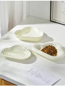Macro shot of cloud-shaped ceramic pet bowls with wave texture and smiling face design