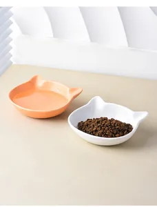Close-up of ceramic cat ear bowls in soft orange and white for food and water