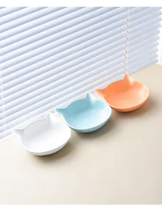 Macro view of ceramic cat-ear bowls in white, light blue and orange matte finish